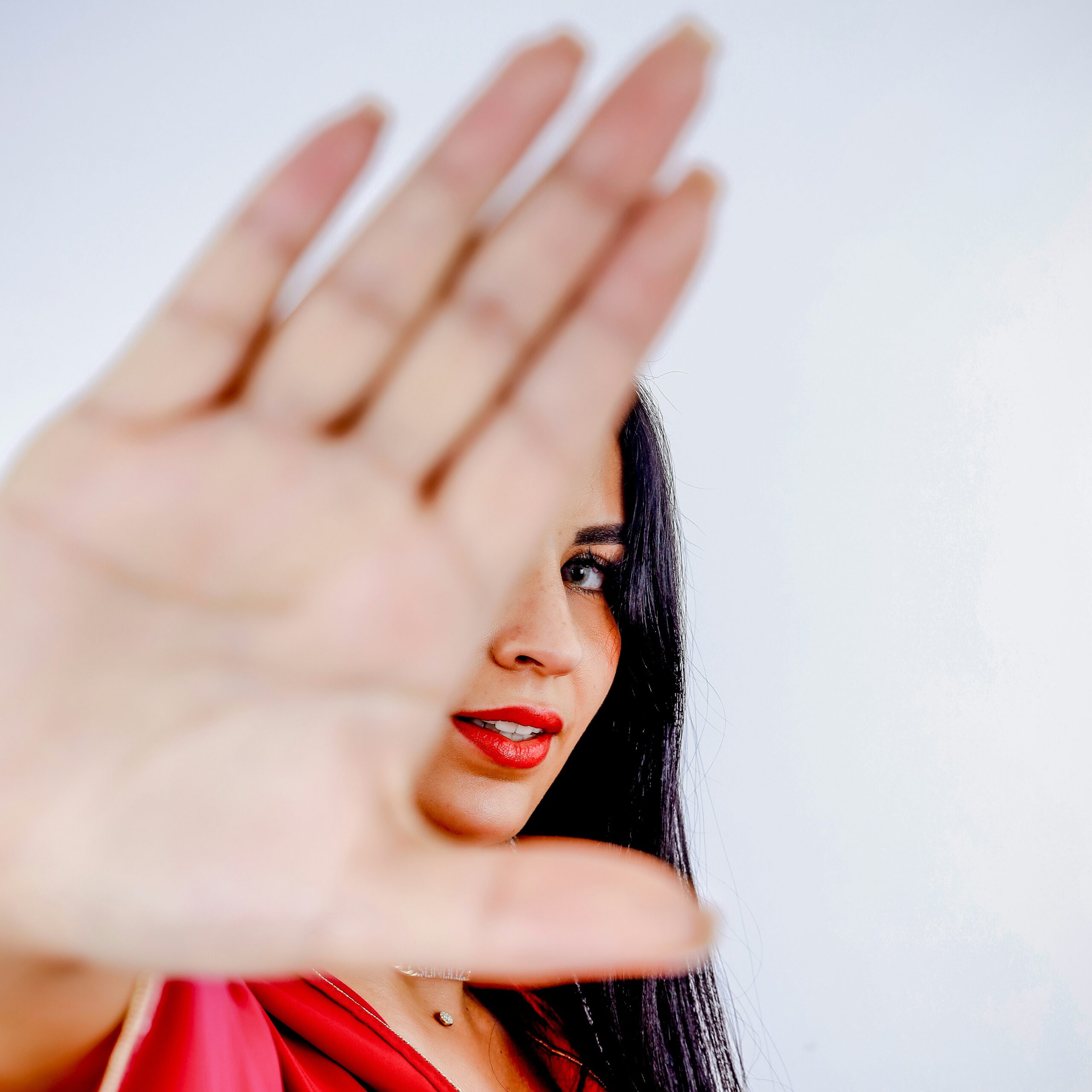 a woman in a red dress making a hand gesture